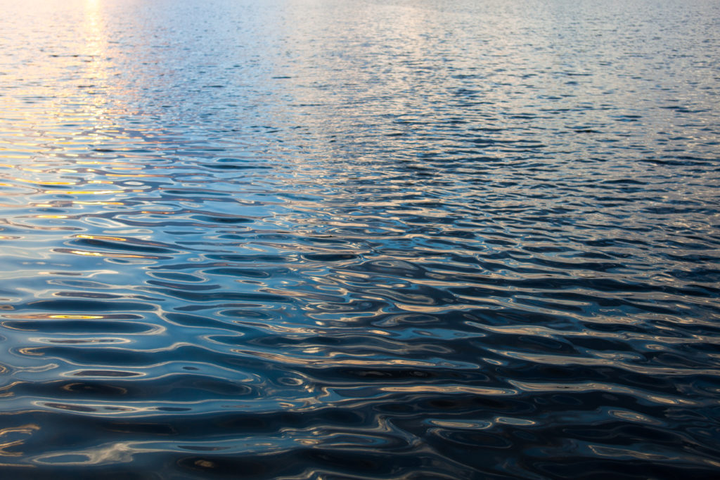 Water surface with ripples and sunrays reflections - Cheap Flood Insurance